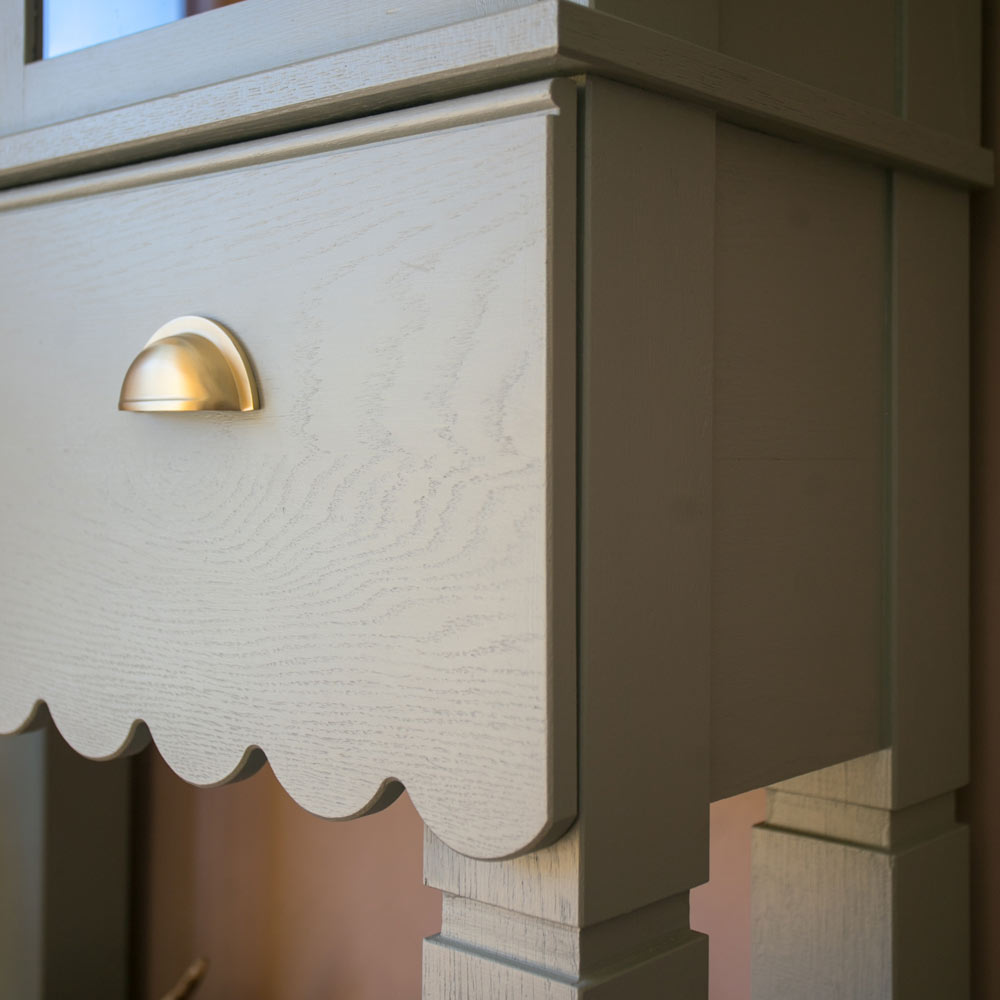 Zásuvka sekretára Erita sivozelená farba so zlatou úchytkou.